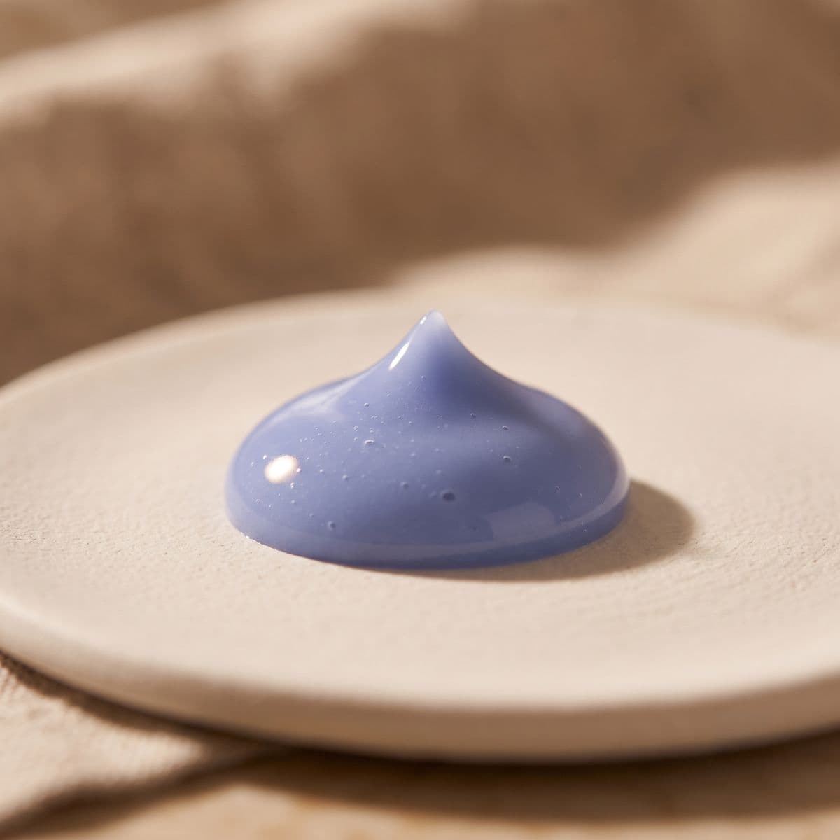 The blue formula of Stratuum Cohesion cream, shown in close-up.